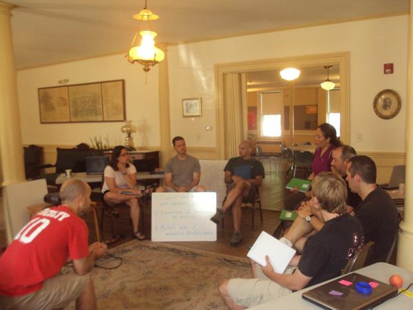 several people sit in a circle discussing workshop content